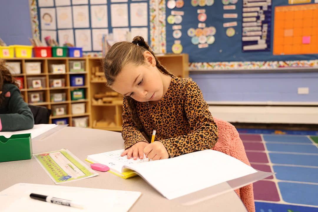 young girl at school writing in notebook