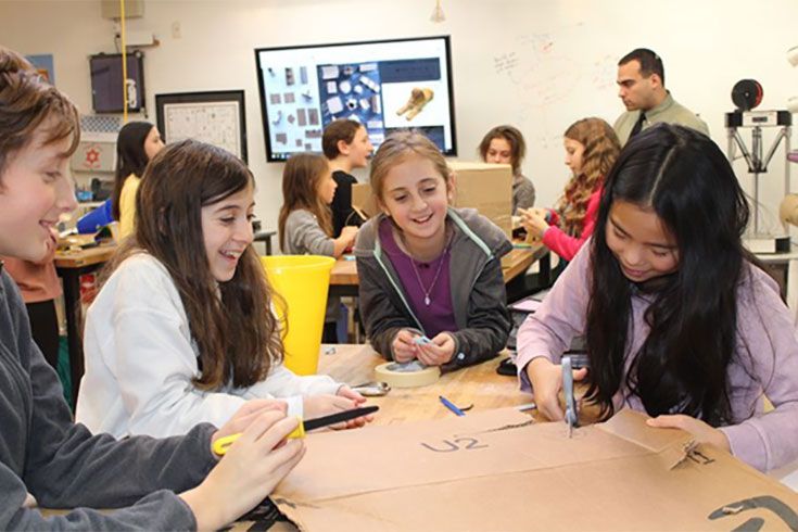 Students engaged in teamwork while working on a project in a classroom environment.