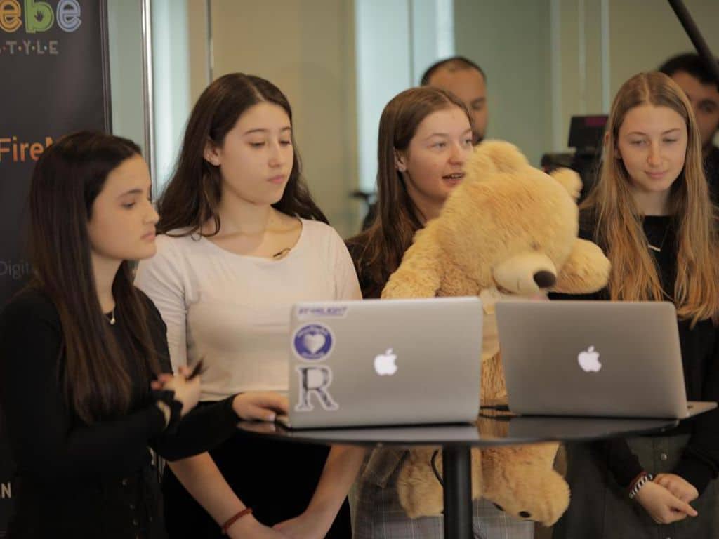 Four girls standing with their comupers